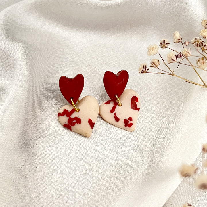 Clay earrings with dangling red hearts