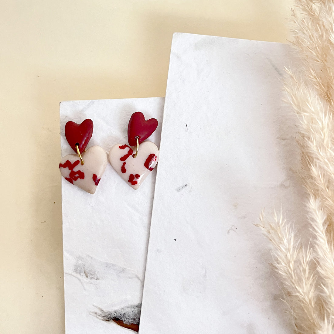 Two-tone red and cream heart dangle earrings