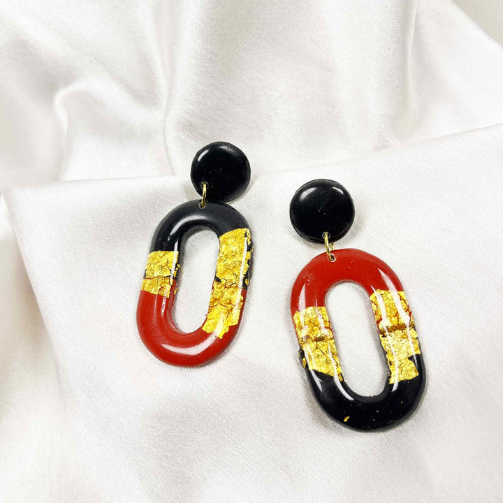 Black and red oval dangle earrings with gold foil