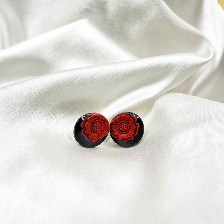 Red floral clay stud earrings on black base