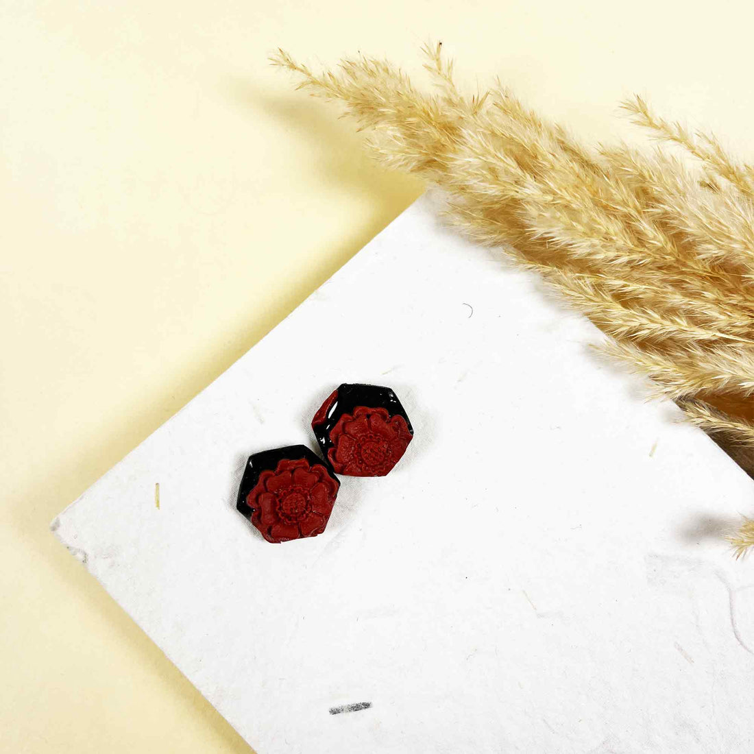 Artisan red floral earrings on satin background